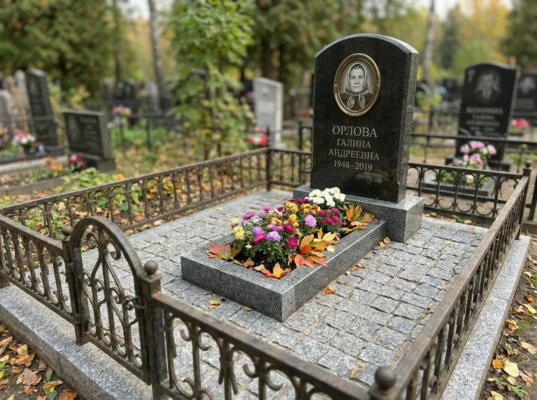 Благоустроенное захоронение с гранитной плиткой, оградой и цветником в Волгограде