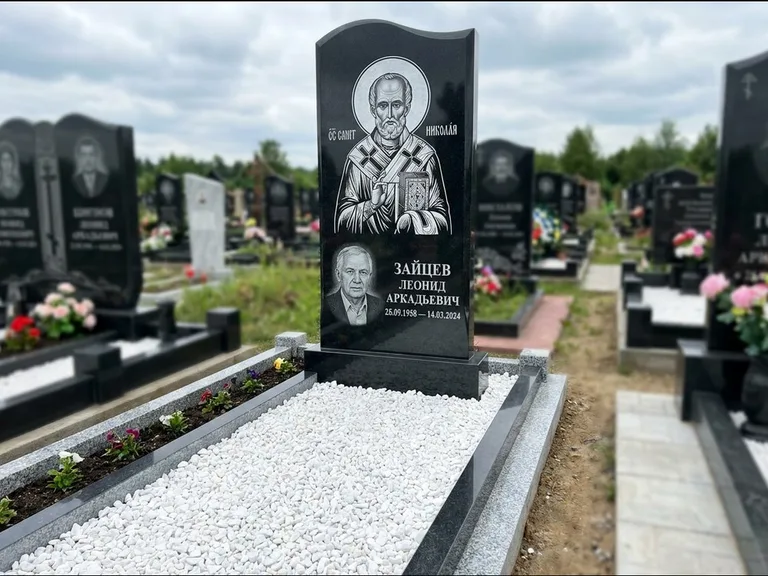 Памятник с гравировкой иконы: стела с крестообразным навершием — икона в резной рамке-киоте, газон без ограды, стриженая трава, работа «Раевская» в Волгограде