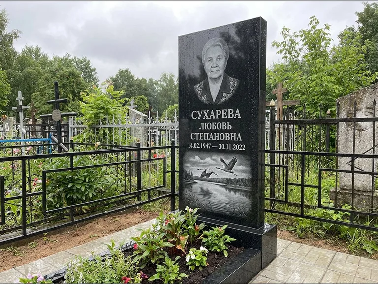 Памятник с гравировкой журавлей — гравировка пары журавлей над гладью озера в нижней части, работа «Сухарева» в Волгограде